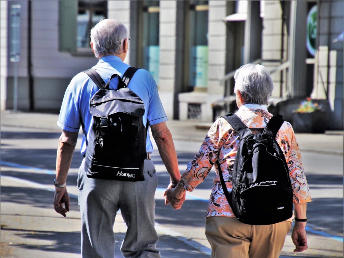 senior couple wearing backpacks