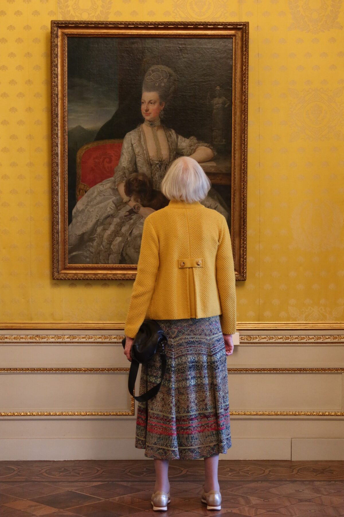 older woman looking at painting