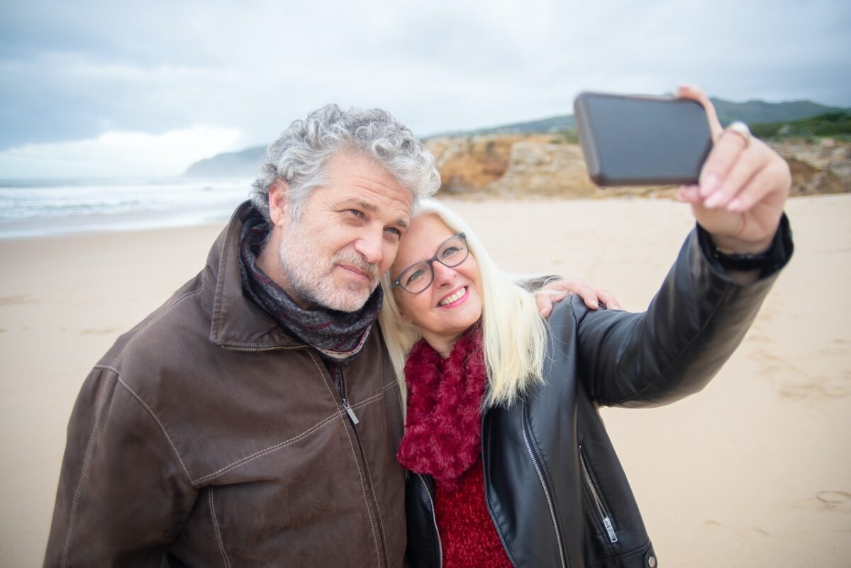 senior couple taking selfie at beach