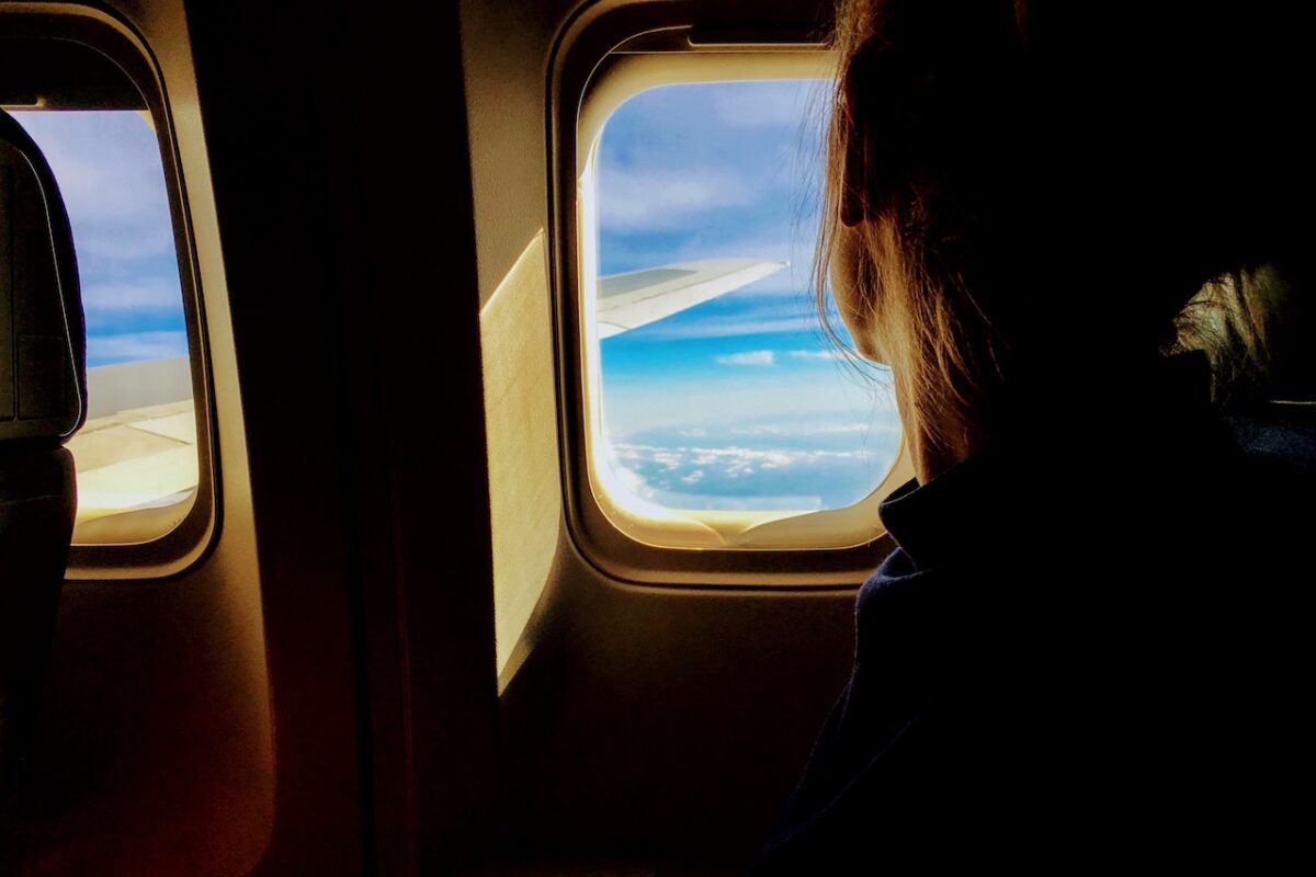person looking out airplane window
